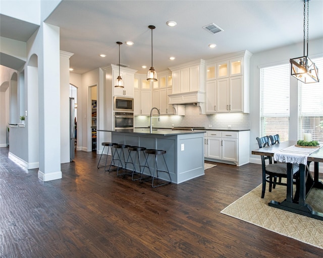 2624 Seabiscuit Rd, Celina, TX 75009 - kitchen featuring appliances with stainless steel finishes, dark countertops, arched walkways, tasteful backsplash, and baseboards