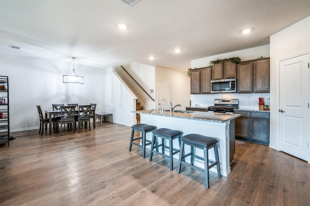 1601 Pecan Orchard Dr, Princeton, TX 75407 - kitchen with stainless steel appliances, a sink, light stone countertops, a kitchen bar, and an island with sink
