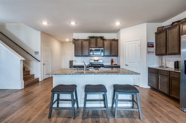 1601 Pecan Orchard Dr, Princeton, TX 75407 - kitchen with appliances with stainless steel finishes, a sink, decorative backsplash, a kitchen breakfast bar, and recessed lighting
