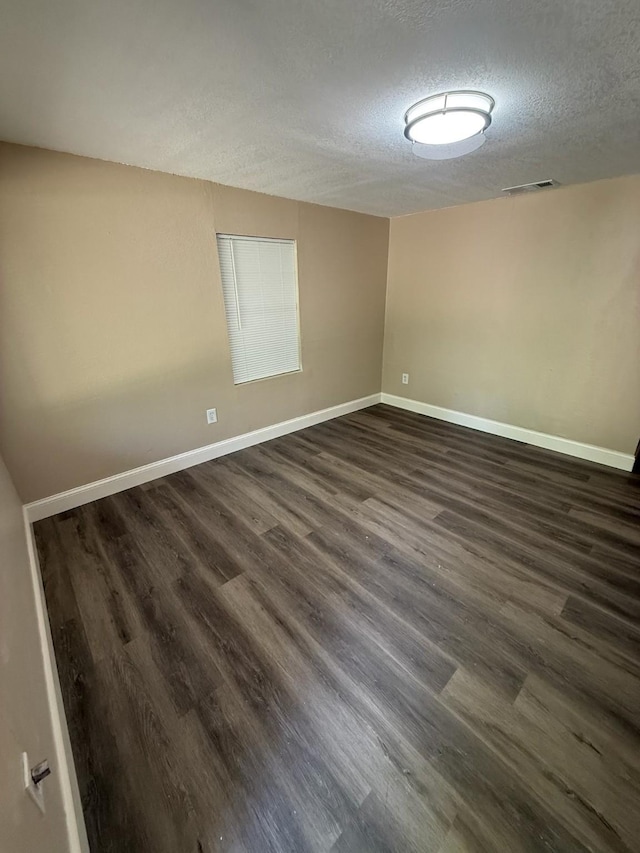 602 Pierson St, Lancaster, TX 75146 - spare room with a textured ceiling, dark wood-style floors, and baseboards