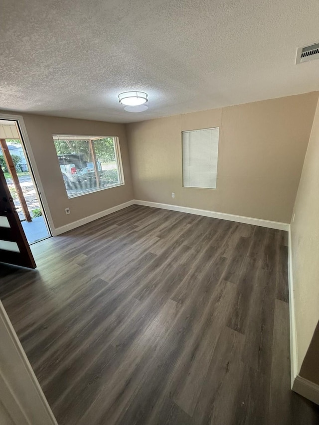 602 Pierson St, Lancaster, TX 75146 - spare room with a textured ceiling, dark wood finished floors, and baseboards
