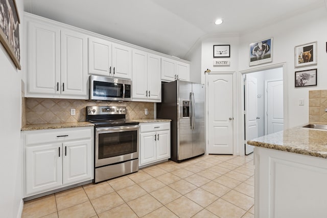 816 Claycourt Cir, Fort Worth, TX 76120 - kitchen featuring stainless steel appliances, tasteful backsplash, white cabinets, recessed lighting, and lofted ceiling