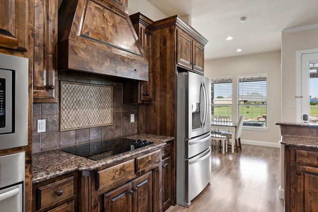 14208 Lucille Dr, Newark, TX 76071 - kitchen featuring stainless steel appliances, custom range hood, tasteful backsplash, dark brown cabinetry, and dark stone countertops