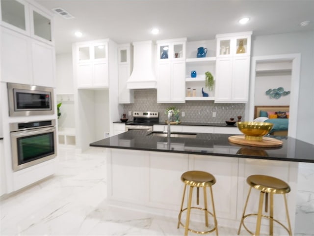 2217 S Peachtree Ct, Denison, TX 75020 - kitchen with stainless steel appliances, premium range hood, white cabinets, open shelves, and backsplash