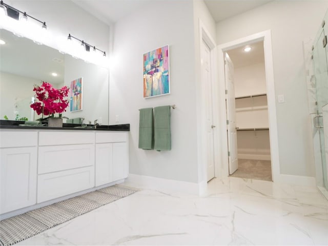 2217 S Peachtree Ct, Denison, TX 75020 - bathroom featuring double vanity, a shower stall, baseboards, marble finish floors, and a spacious closet