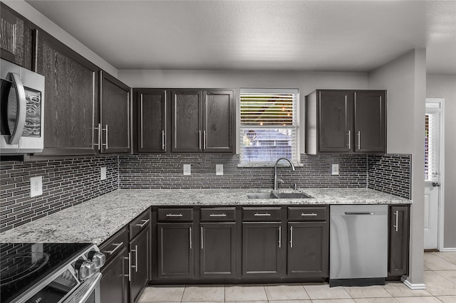 8002 Stowe Springs Ln, Arlington, TX 76002 - kitchen with a sink, appliances with stainless steel finishes, light tile patterned floors, backsplash, and light stone countertops