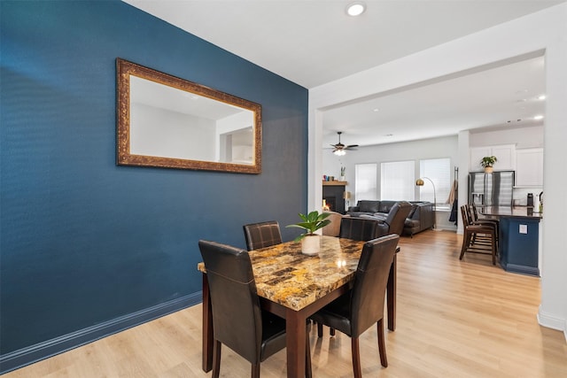 2603 Loxley Dr, Mansfield, TX 76084 - dining space with light wood-style flooring, a lit fireplace, recessed lighting, baseboards, and ceiling fan