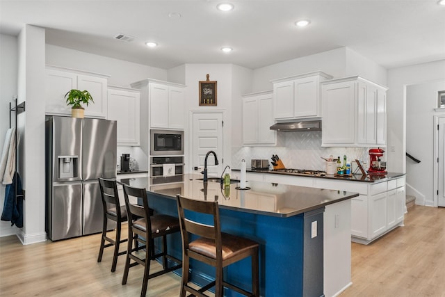 2603 Loxley Dr, Mansfield, TX 76084 - kitchen with appliances with stainless steel finishes, a sink, dark countertops, a kitchen bar, and white cabinets