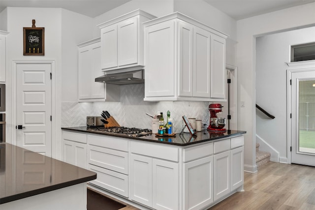 2603 Loxley Dr, Mansfield, TX 76084 - kitchen with stainless steel appliances, dark countertops, decorative backsplash, under cabinet range hood, and white cabinetry
