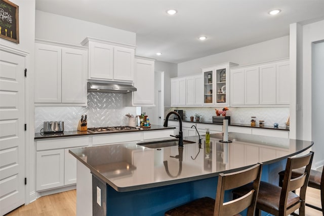 2603 Loxley Dr, Mansfield, TX 76084 - kitchen featuring a sink, under cabinet range hood, dark countertops, a kitchen bar, and recessed lighting