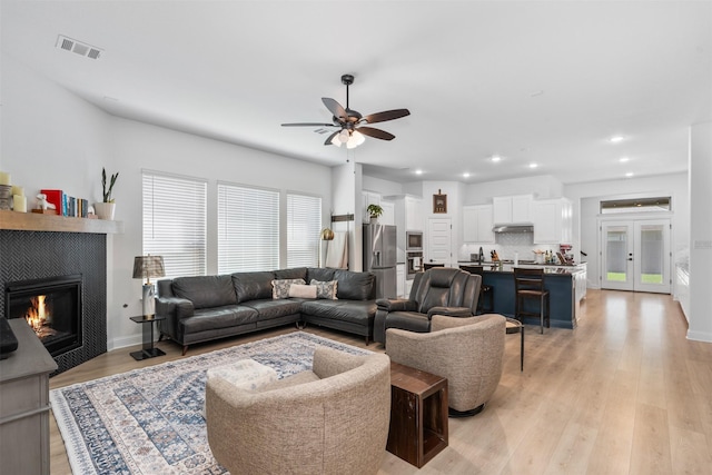 2603 Loxley Dr, Mansfield, TX 76084 - living room featuring ceiling fan, recessed lighting, a tiled fireplace, light wood-style flooring, and baseboards