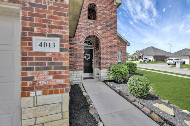 4013 Vista Greens Dr, Fort Worth, TX 76244 - view of exterior entry featuring brick siding and a yard