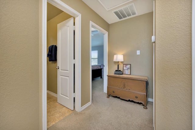4013 Vista Greens Dr, Fort Worth, TX 76244 - hall featuring a textured wall, light carpet, attic access, light tile patterned floors, and baseboards