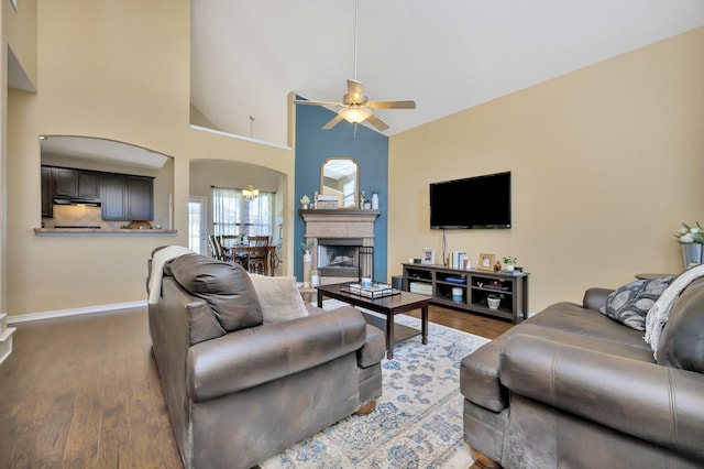 4013 Vista Greens Dr, Fort Worth, TX 76244 - living room featuring a ceiling fan, arched walkways, dark wood-type flooring, baseboards, and a fireplace