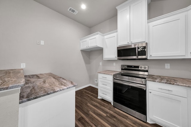 209 NE 6th Ave, Mineral Wells, TX 76067 - kitchen featuring stainless steel appliances, baseboards, dark wood-style floors, and white cabinetry