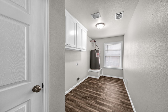 209 NE 6th Ave, Mineral Wells, TX 76067 - laundry area featuring hookup for an electric dryer, baseboards, dark wood finished floors, cabinet space, and water heater
