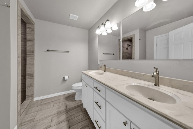 209 NE 6th Ave, Mineral Wells, TX 76067 - full bathroom featuring a tile shower, double vanity, toilet, and baseboards