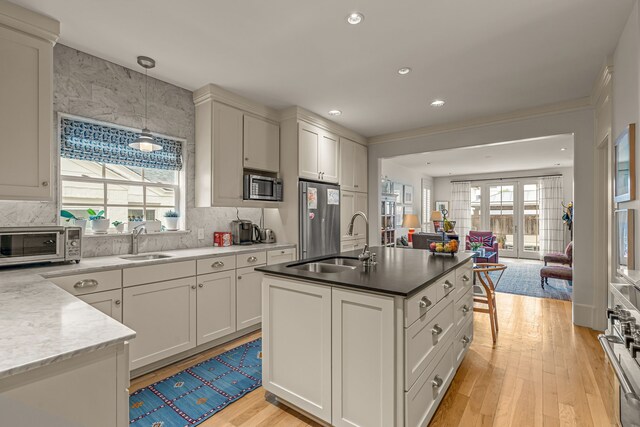 3766 W 4th St, Fort Worth, TX 76107 - kitchen with appliances with stainless steel finishes, a sink, open floor plan, light wood-style floors, and recessed lighting