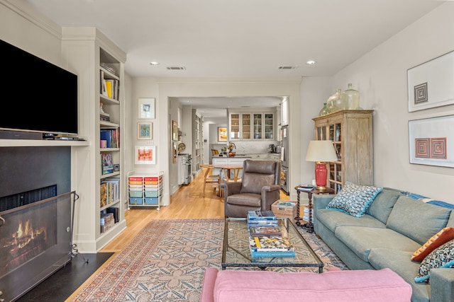 3766 W 4th St, Fort Worth, TX 76107 - living area featuring a warm lit fireplace, light wood-style floors, and recessed lighting