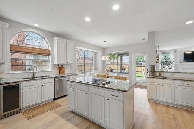 7205 Fair Valley Way, Plano, TX 75024 - kitchen featuring a sink, dishwasher, black electric stovetop, light wood finished floors, and a center island