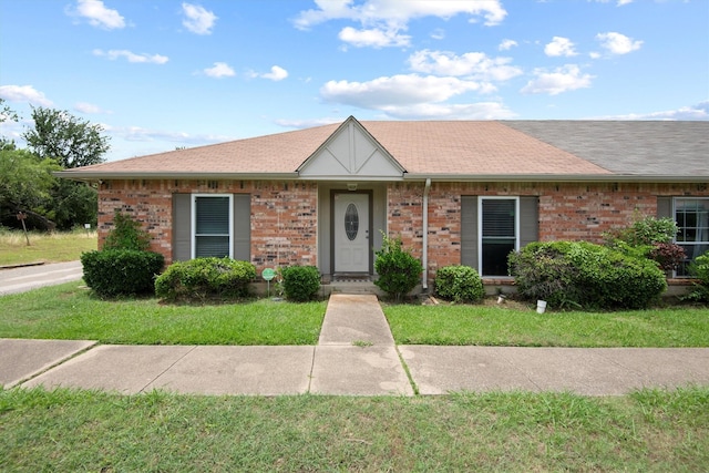 31 W Townhouse Ln Unit 20, Grand Prairie, TX 75052 - view of front of property featuring a front yard, brick siding, and a shingled roof
