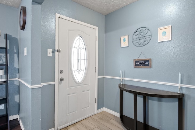 31 W Townhouse Ln Unit 20, Grand Prairie, TX 75052 - foyer featuring light wood-style floors, baseboards, a textured ceiling, and a textured wall