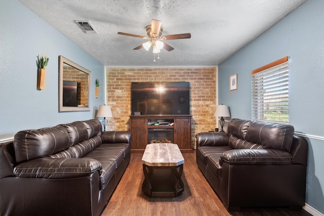 31 W Townhouse Ln Unit 20, Grand Prairie, TX 75052 - living room featuring ceiling fan, wood finished floors, a textured ceiling, and brick wall