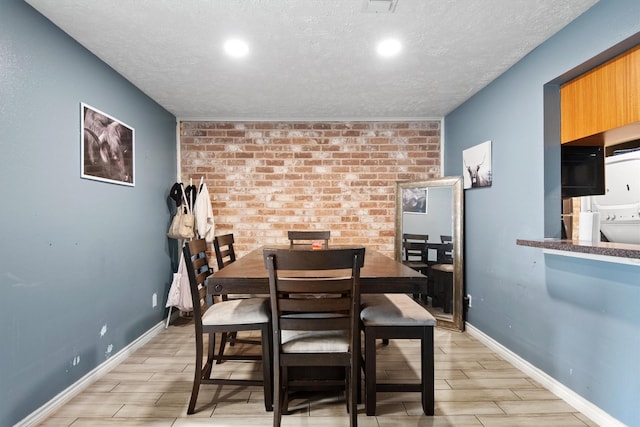 31 W Townhouse Ln Unit 20, Grand Prairie, TX 75052 - dining area featuring wood finish floors, a textured ceiling, baseboards, recessed lighting, and brick wall