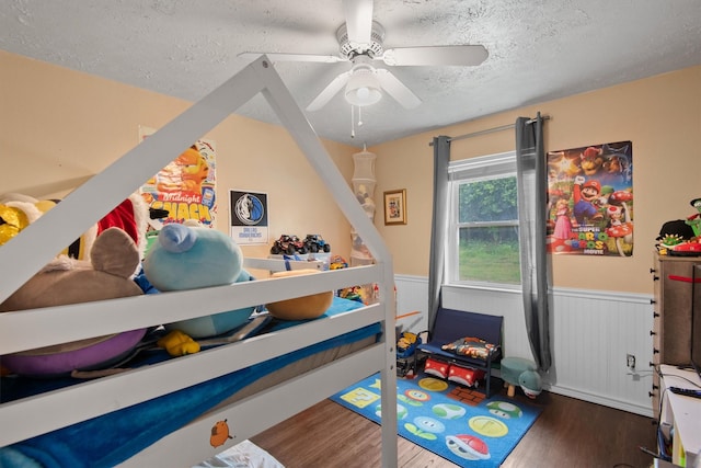 31 W Townhouse Ln Unit 20, Grand Prairie, TX 75052 - recreation room featuring a textured ceiling, a wainscoted wall, wood finished floors, and ceiling fan