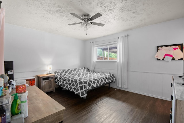 31 W Townhouse Ln Unit 20, Grand Prairie, TX 75052 - bedroom with dark wood-type flooring, a textured ceiling, wainscoting, and ceiling fan