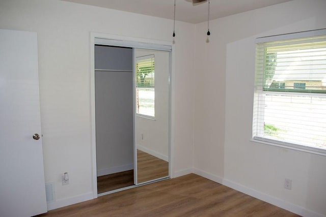 731 E Cherry St, Duncanville, TX 75116 - unfurnished bedroom with a closet, wood finished floors, and baseboards