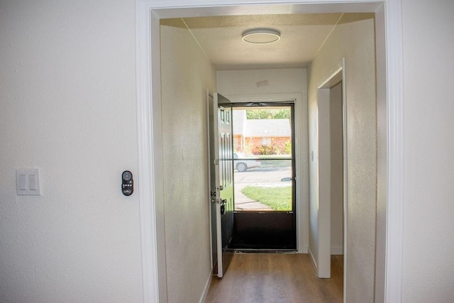 731 E Cherry St, Duncanville, TX 75116 - doorway featuring wood finished floors, baseboards, and a textured wall