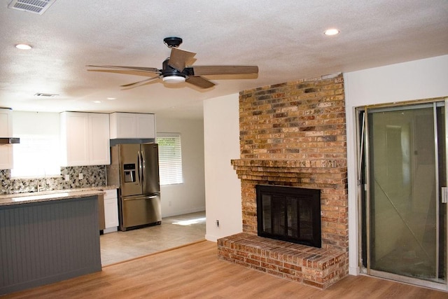731 E Cherry St, Duncanville, TX 75116 - kitchen with stainless steel refrigerator with ice dispenser, ceiling fan, white cabinets, light wood-style flooring, and tasteful backsplash