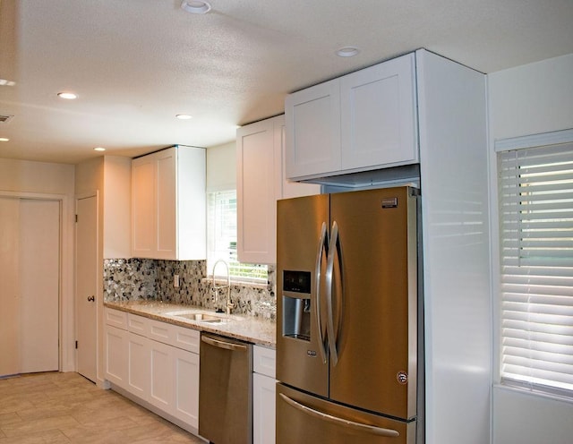 731 E Cherry St, Duncanville, TX 75116 - kitchen with appliances with stainless steel finishes, a sink, white cabinets, decorative backsplash, and recessed lighting