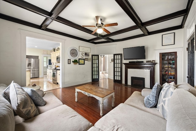 100 Corsicana St, Hillsboro, TX 76645 - living room featuring coffered ceiling, wood finished floors, a ceiling fan, beam ceiling, and a fireplace
