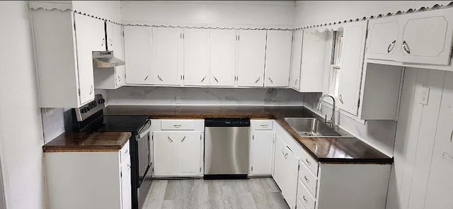 401 Frisco St, Cumby, TX 75433 - kitchen featuring stainless steel appliances, a sink, dark countertops, under cabinet range hood, and white cabinetry