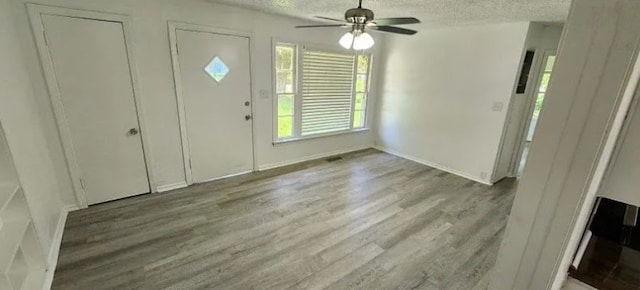 401 Frisco St, Cumby, TX 75433 - foyer entrance featuring a textured ceiling, wood finished floors, ceiling fan, and baseboards
