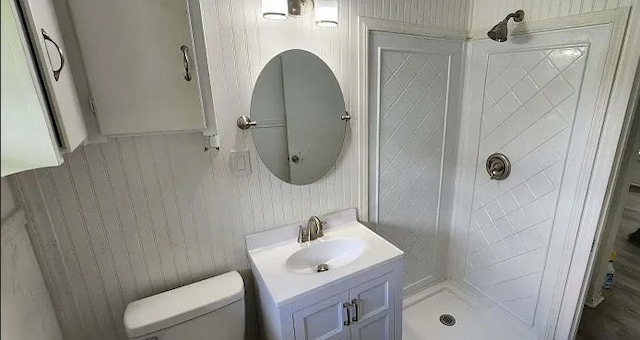 401 Frisco St, Cumby, TX 75433 - bathroom featuring vanity, toilet, a tile shower, and wooden walls