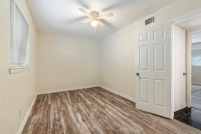 3406 Schwartz Ave, Fort Worth, TX 76106 - unfurnished room featuring a ceiling fan, a textured ceiling, wood finished floors, and baseboards