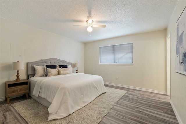 3406 Schwartz Ave, Fort Worth, TX 76106 - bedroom featuring wood finished floors, a textured ceiling, a ceiling fan, and baseboards