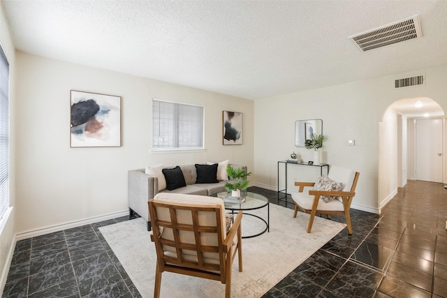 3406 Schwartz Ave, Fort Worth, TX 76106 - living area with arched walkways, marble finish floors, a textured ceiling, and baseboards