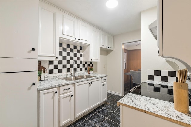 3406 Schwartz Ave, Fort Worth, TX 76106 - kitchen featuring a sink, tasteful backsplash, white cabinetry, and dark marble finish floors