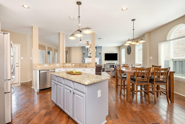 2916 Woods Dr, Plano, TX 75025 - kitchen featuring stainless steel appliances, a kitchen island, a sink, dark wood-style floors, and hanging light fixtures