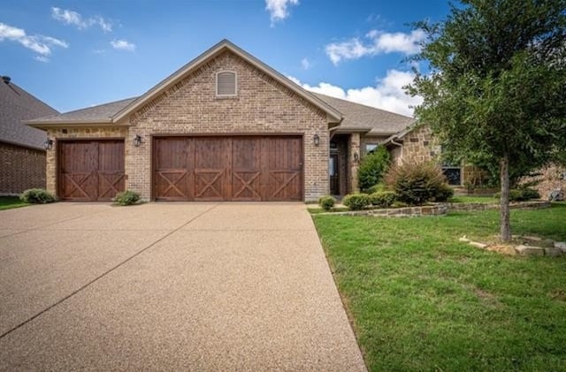1017 Thistle Hill Trl, Weatherford, TX 76087 - view of front of home with a garage, concrete driveway, a front yard, and brick siding