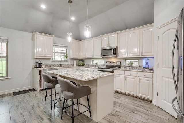1017 Thistle Hill Trl, Weatherford, TX 76087 - kitchen featuring appliances with stainless steel finishes, white cabinetry, a breakfast bar area, high vaulted ceiling, and a center island