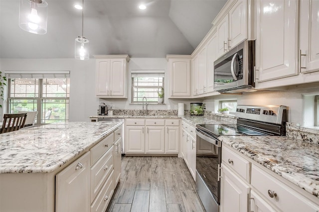 1017 Thistle Hill Trl, Weatherford, TX 76087 - kitchen featuring stainless steel appliances, a sink, lofted ceiling, white cabinets, and light wood-style flooring