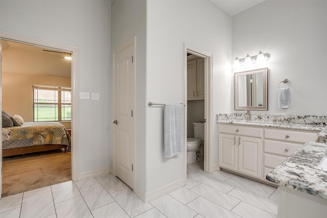 1017 Thistle Hill Trl, Weatherford, TX 76087 - ensuite bathroom featuring vanity, toilet, marble finish flooring, and baseboards