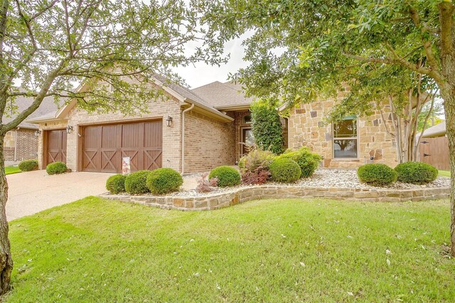 1017 Thistle Hill Trl, Weatherford, TX 76087 - view of front of home with an attached garage, a front lawn, driveway, and brick siding
