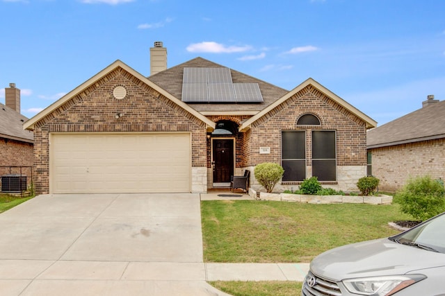318 Green Meadows Rd, Wilmer, TX 75172 - french country home with brick siding, a front yard, roof mounted solar panels, a garage, and a shingled roof