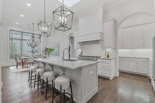 6644 Josephine St, Plano, TX 75024 - kitchen featuring crown molding, a sink, a chandelier, arched walkways, and light stone countertops